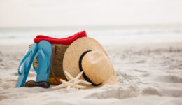 Bag and beach accessories kept on sand